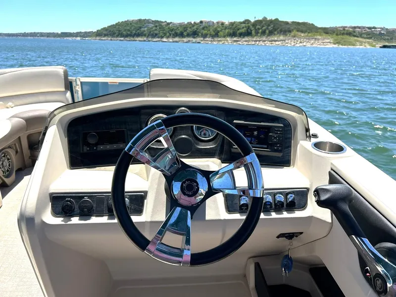 Slide: The Image of Steering wheel of 2022 Avalon 24 LSZ VRB-3 boat on a sunny lake. - 27