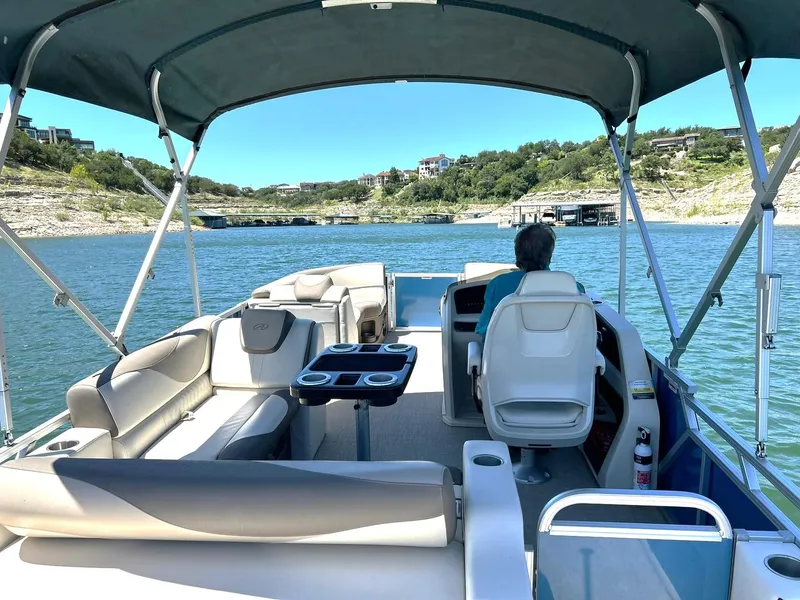 Slide: The Image of 2022 Avalon 24 LSZ VRB-3 pontoon boat cruising on a scenic lake. - 3