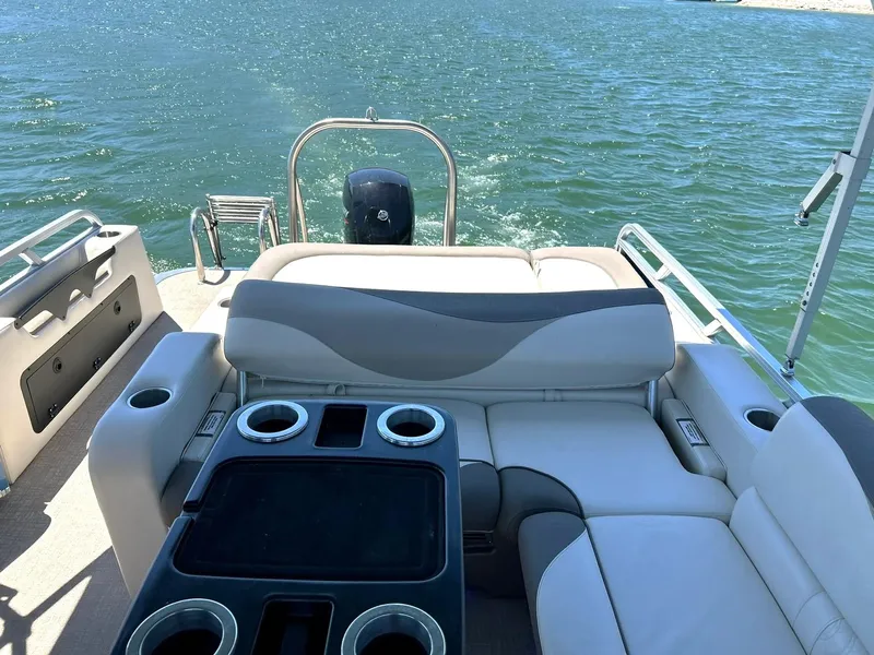 Slide: The Image of 2022 Avalon 24 LSZ VRB-3 pontoon boat interior with seating and cup holders on a lake. - 34