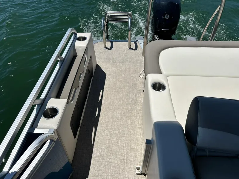 Slide: The Image of 2022 Avalon 24 LSZ VRB-3 boat interior with seating and cup holders on water. - 40