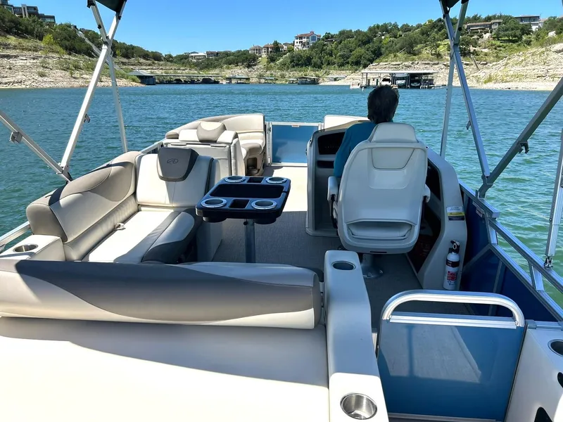 Slide: The Image of 2022 Avalon 24 LSZ VRB-3 pontoon boat on a scenic lake with a person at the helm. - 43