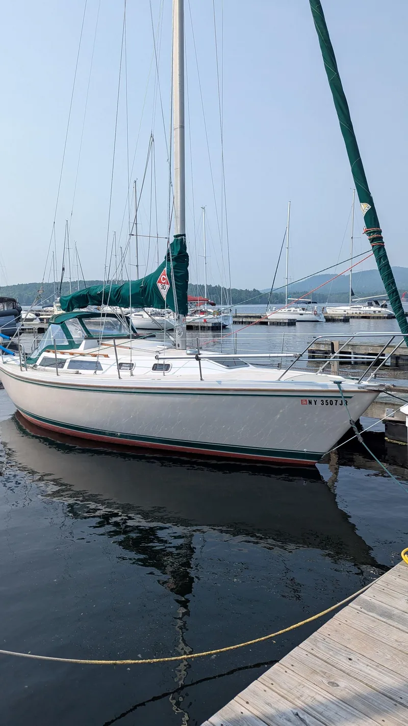 The Image of 1988 Catalina 30 MkII sailboat docked at a marina, calm water, clear sky. - 0