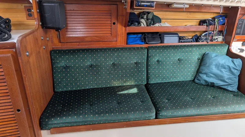 Slide: The Image of Interior of a 1988 Catalina 30 MkII sailboat with green cushioned seating and wooden storage shelves. - 20