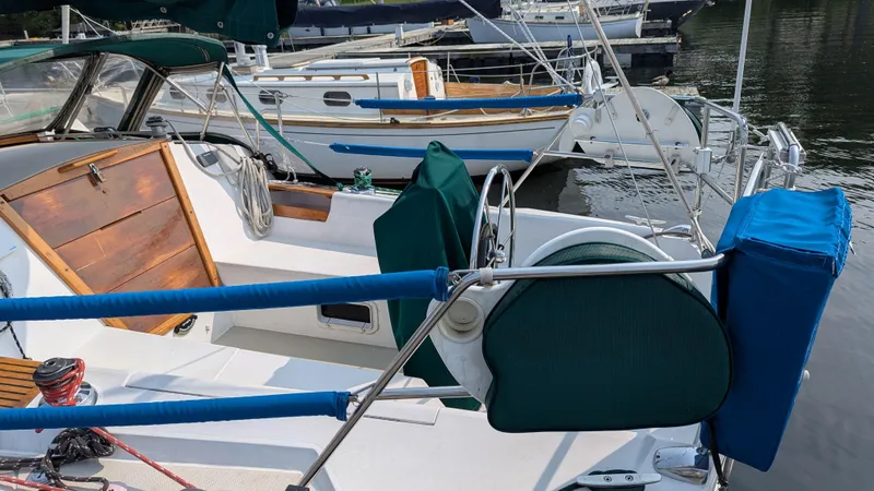 Slide: The Image of 1988 Catalina 30 MkII sailboat docked, featuring a spacious cockpit and wooden hatch. - 3