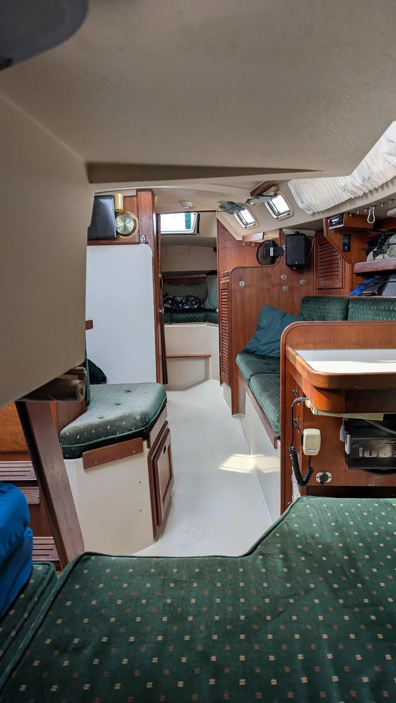 Slide: The Image of Interior of a 1988 Catalina 30 MkII sailboat, featuring cozy seating and wooden cabinetry. - 30