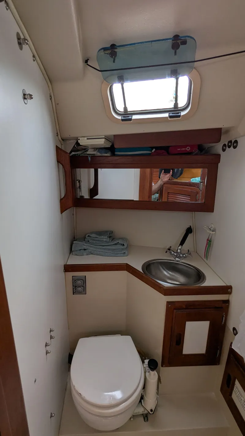 Slide: The Image of 1988 Catalina 30 MkII sailboat bathroom with sink, toilet, and storage. - 32
