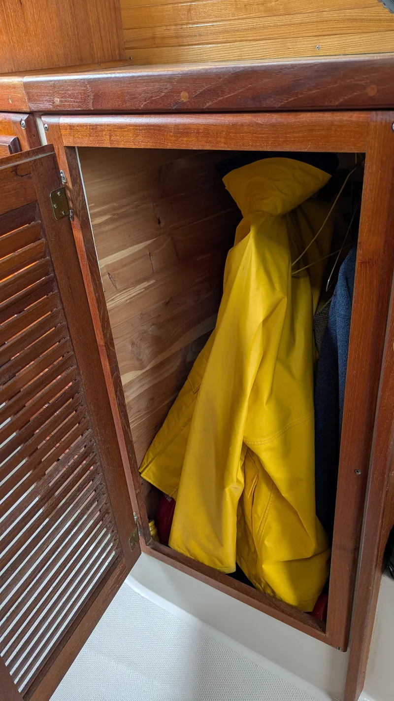 Slide: The Image of Wooden closet on 1988 Catalina 30 MkII sailboat with yellow raincoat inside. - 33