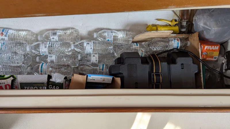 Slide: The Image of Storage compartment in a 1988 Catalina 30 MkII with water bottles and supplies. - 35