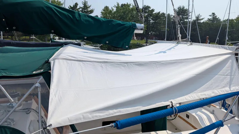 Slide: The Image of 1988 Catalina 30 MkII sailboat with green and white covers docked at marina. - 5