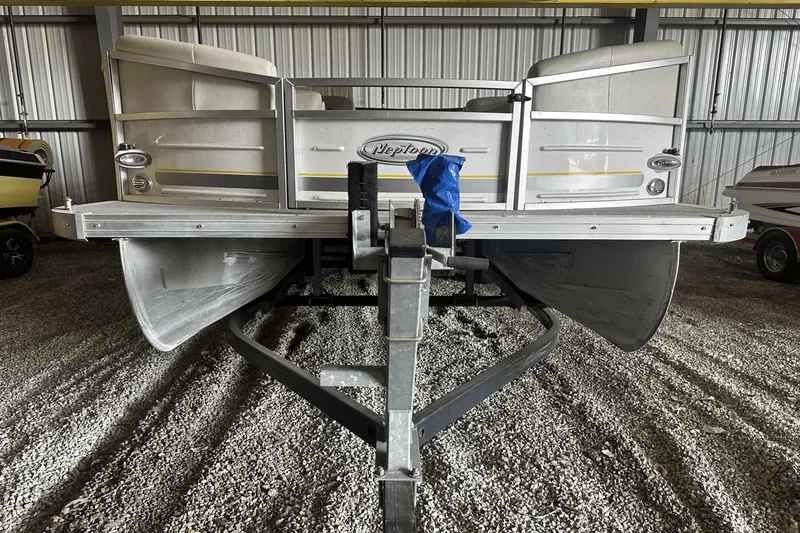 Slide: The Image of 2005 Neptune 23 pontoon boat on trailer in storage facility. - 2