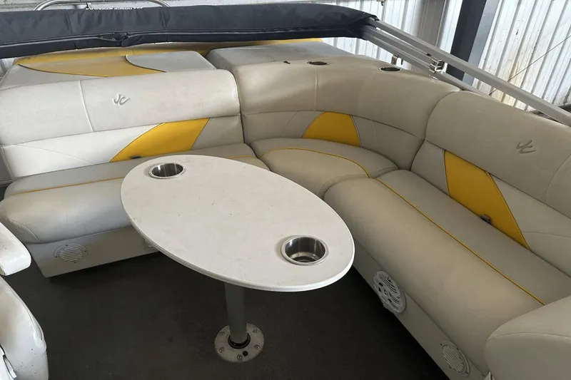 Slide: The Image of Luxurious Neptune 23 boat interior with beige and yellow seating, featuring a central table, 2005 model. - 8