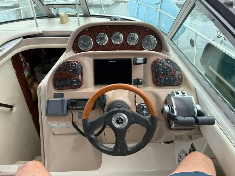 Slide: The Image of Cockpit of 2004 Sea Ray 300 Sundancer with steering wheel and control panel. - 14