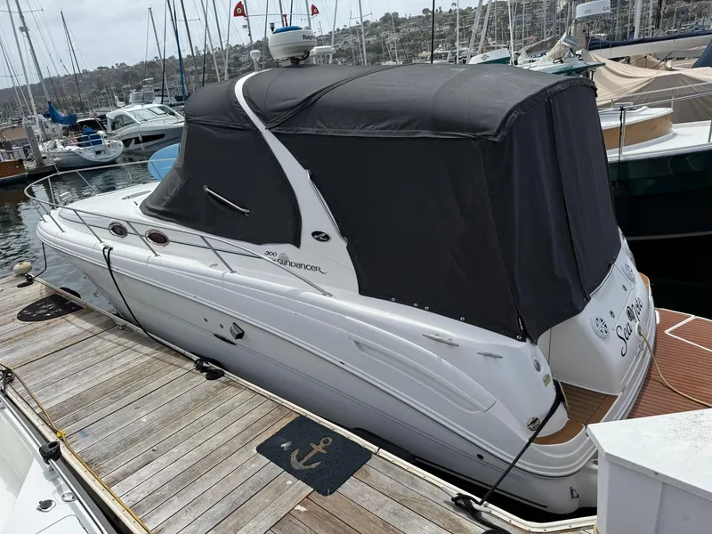 Slide: The Image of 2004 Sea Ray 300 Sundancer docked at marina, covered with black canopy. - 18
