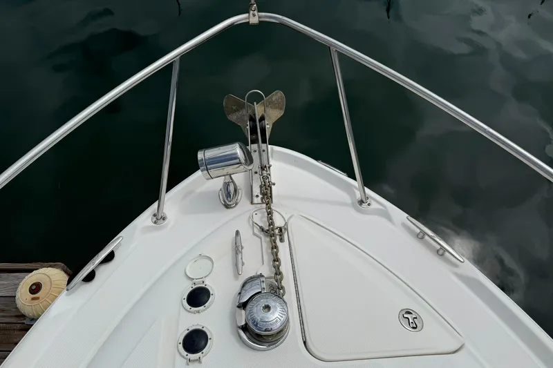 Slide: The Image of Bow of 2004 Sea Ray 300 Sundancer with anchor and railing, docked on calm water. - 19