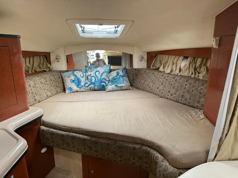 Slide: The Image of 2004 Sea Ray 300 Sundancer cabin interior with patterned cushions and decorative pillows. - 6