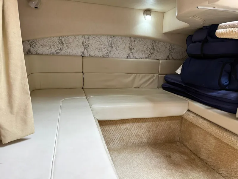 Slide: The Image of 2004 Sea Ray 300 Sundancer cabin interior with beige seating and nautical decor. - 7