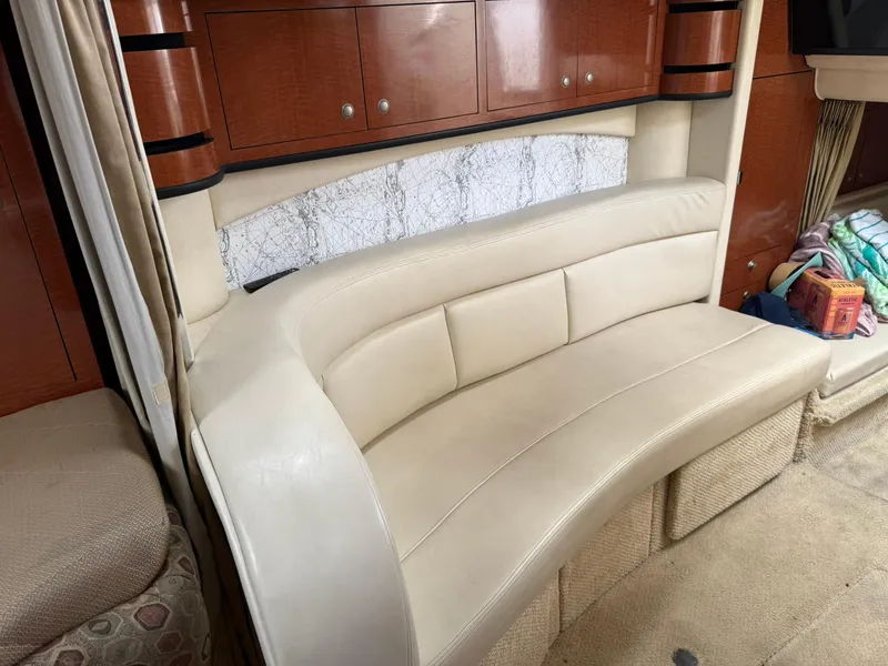 Slide: The Image of Interior of 2004 Sea Ray 300 Sundancer with beige leather seating and wooden cabinets. - 8