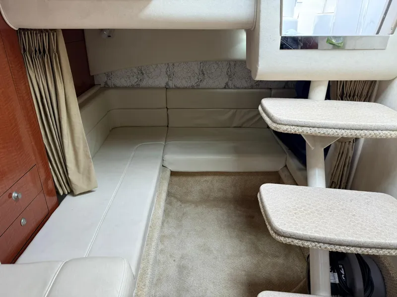 Slide: The Image of Interior of 2004 Sea Ray 300 Sundancer with beige seating and carpeted floor. - 9