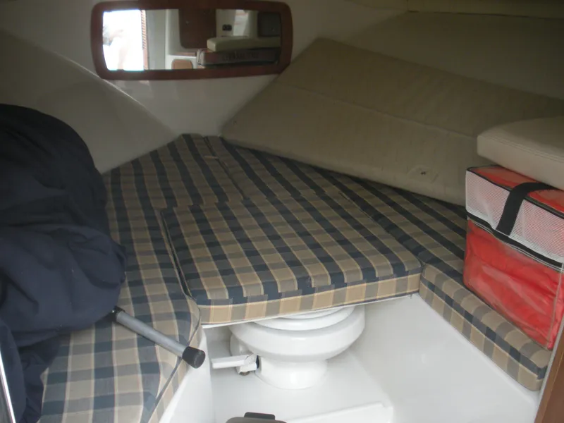 Slide: The Image of 2006 Chris-Craft Corsair 28 cabin interior with plaid cushions and compact toilet. - 12