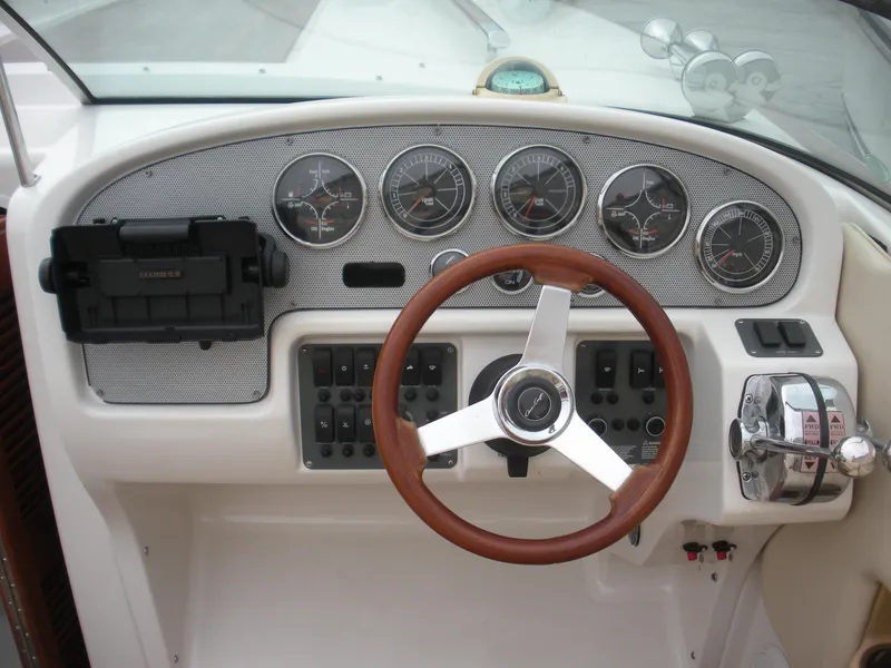 Slide: The Image of 2006 Chris-Craft Corsair 28 dashboard with gauges, wooden steering wheel, and control panel. - 15