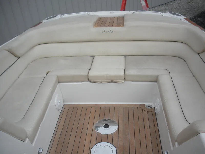 Slide: The Image of 2006 Chris-Craft Corsair 28 boat interior with beige seating and wooden flooring. - 18