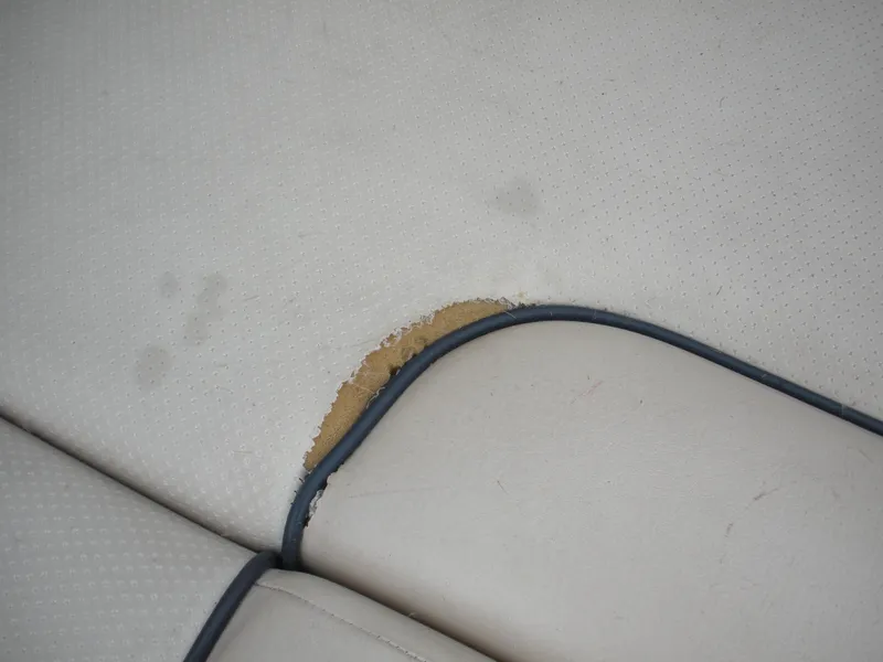 Slide: The Image of Worn upholstery on 2006 Chris-Craft Corsair 28 boat seat, showing visible damage. - 19