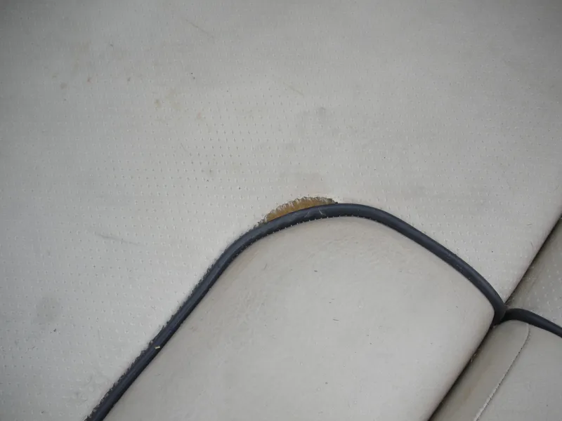 Slide: The Image of Worn upholstery on 2006 Chris-Craft Corsair 28 boat seat, showing visible damage. - 20