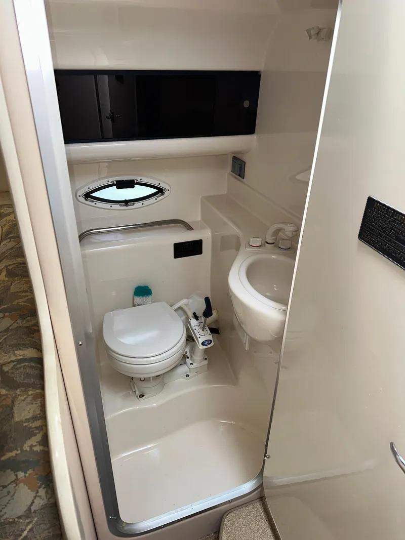 Slide: The Image of 2000 Bayliner 2855 Ciera boat bathroom with toilet, sink, and storage cabinet. - 14