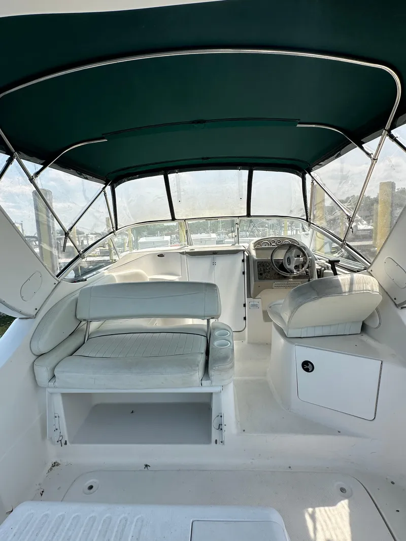 Slide: The Image of 2000 Bayliner 2855 Ciera boat interior with seating and steering wheel under canopy. - 5