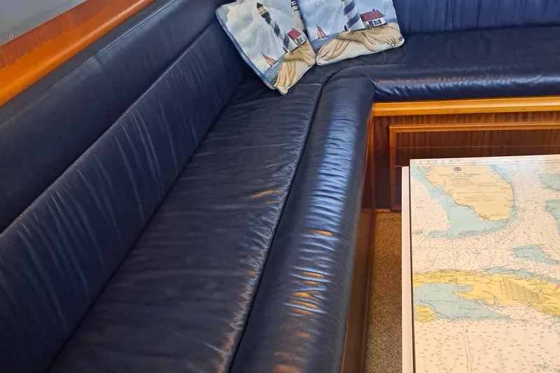 Slide: The Image of Interior of 1978 Hatteras 37 Convertible with blue leather seating and nautical chart table. - 14