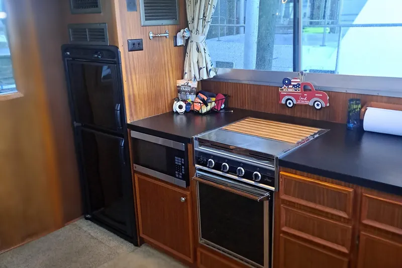 Slide: The Image of 1978 Hatteras 37 Convertible kitchen with stove, microwave, and refrigerator. - 15