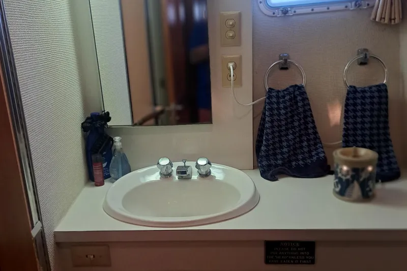 Slide: The Image of Bathroom sink area on a 1978 Hatteras 37 Convertible yacht with towels and toiletries. - 20