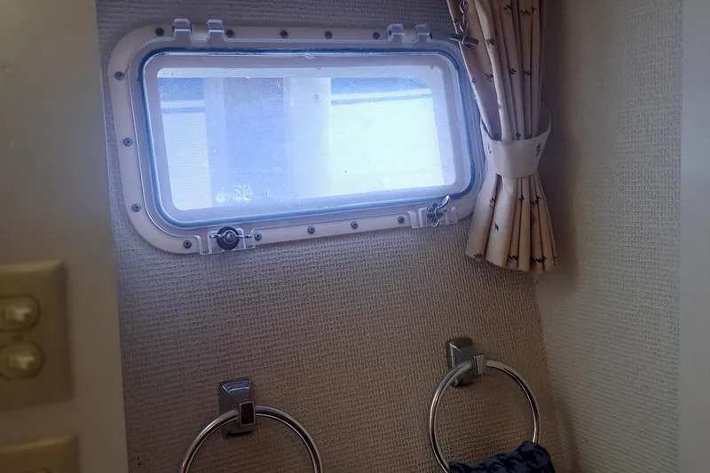 Slide: The Image of 1978 Hatteras 37 Convertible interior with porthole window and curtain. - 23
