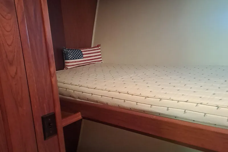 Slide: The Image of 1978 Hatteras 37 Convertible cabin with American flag pillow on a single bed. - 25