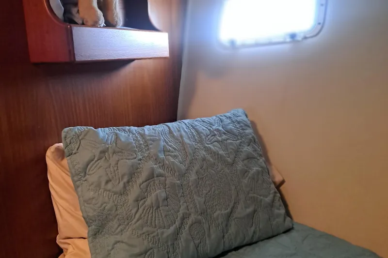 Slide: The Image of Cozy cabin interior of 1978 Hatteras 37 Convertible with quilted bedding and wooden shelf. - 27