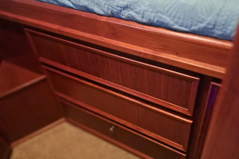 Slide: The Image of Wooden cabinetry inside a 1978 Hatteras 37 Convertible boat, featuring a blue quilted bedspread. - 28