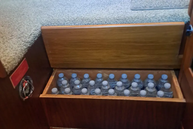 Slide: The Image of Storage compartment with water bottles on a 1978 Hatteras 37 Convertible boat. - 30