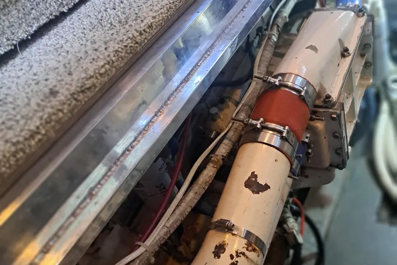 Slide: The Image of Engine compartment of a 1978 Hatteras 37 Convertible boat, showing pipes and metal components. - 34