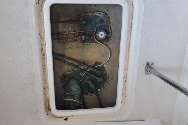 Slide: The Image of Engine compartment of 1978 Hatteras 37 Convertible boat, showing mechanical components and pipes. - 43