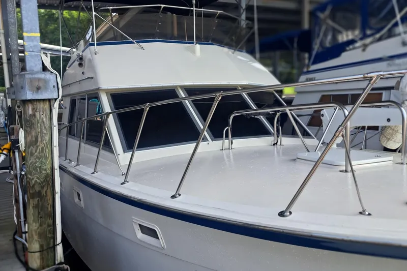 Slide: The Image of 1978 Hatteras 37 Convertible yacht docked, featuring sleek design and sturdy railings. - 5