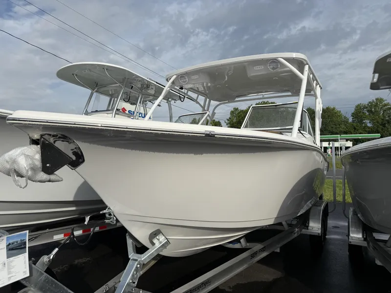 Slide: The Image of 2025 Sea Pro 240 DLX boat on trailer under cloudy sky. - 1