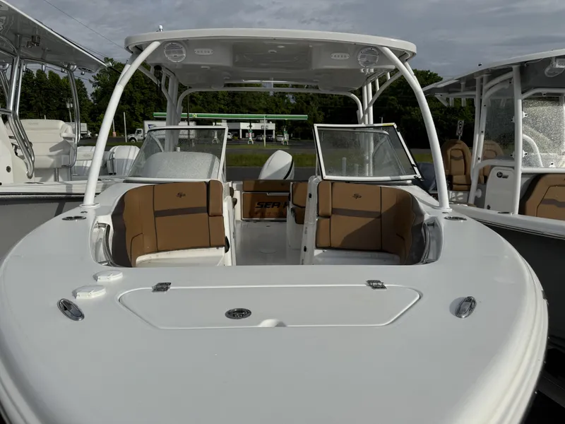 Slide: The Image of 2025 Sea Pro 240 DLX boat with tan seating and sleek design. - 2