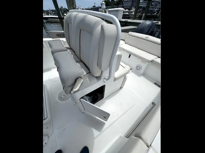 Slide: The Image of 2022 Sea Hunt Ultra 275 SE boat interior with cushioned seating and storage compartment. - 12