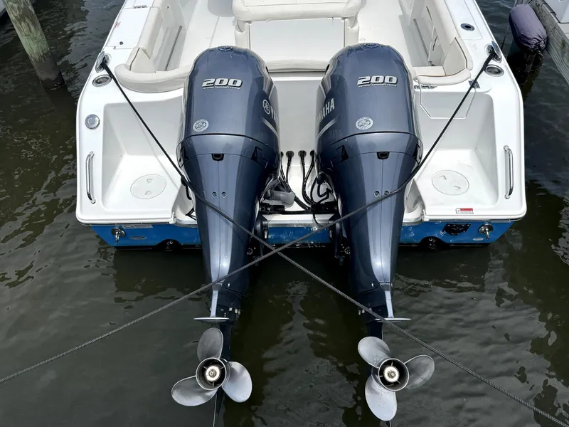 Slide: The Image of 2022 Sea Hunt Ultra 275 SE with dual Yamaha 200 engines docked in water. - 13