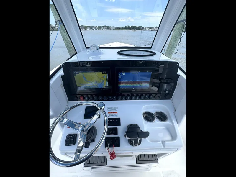 Slide: The Image of 2022 Sea Hunt Ultra 275 SE helm with navigation screens and steering wheel. - 17
