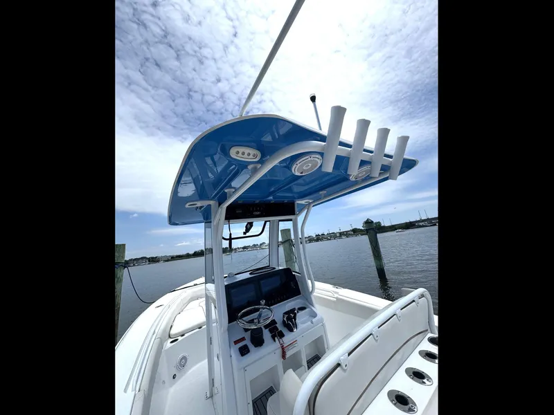 Slide: The Image of 2022 Sea Hunt Ultra 275 SE boat interior with blue canopy and steering console. - 38