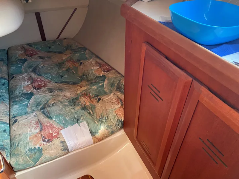 Slide: The Image of Interior of 1996 Hunter 336 sailboat with patterned bedding and wooden cabinetry. - 17