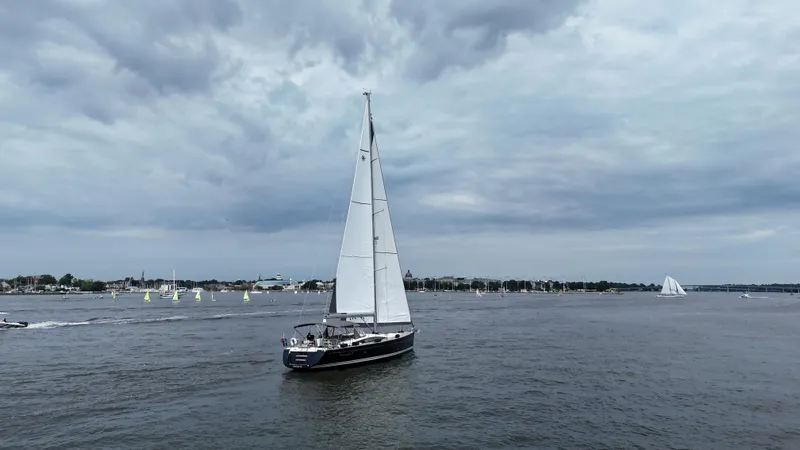Slide: The Image of 2016 Jeanneau Yachts 58 sailing on a cloudy day, surrounded by other boats. - 23