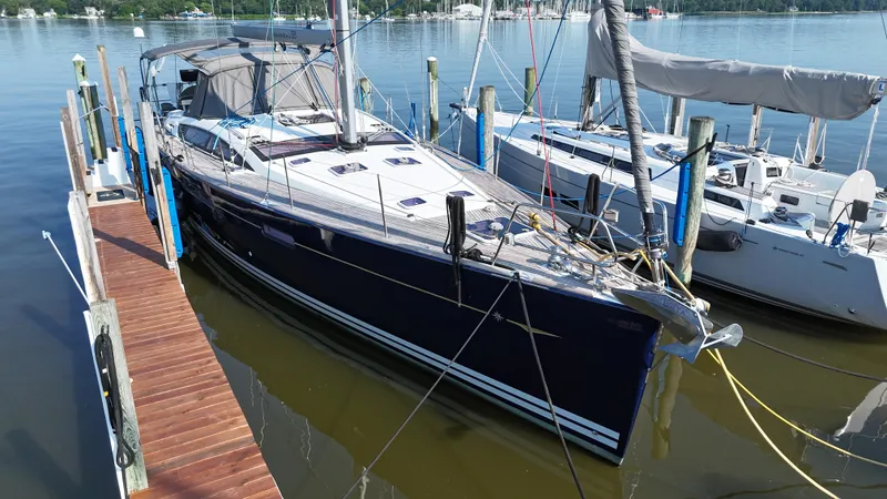 The Image of 2016 Jeanneau Yachts 58 docked at marina, sleek design, calm water, sunny day. - 0