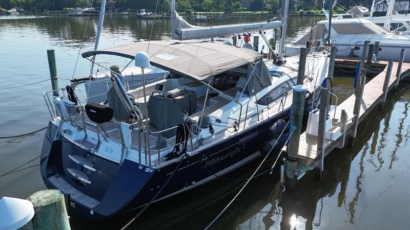 Slide: The Image of 2016 Jeanneau Yachts 58 docked at a marina, featuring sleek design and spacious deck. - 3